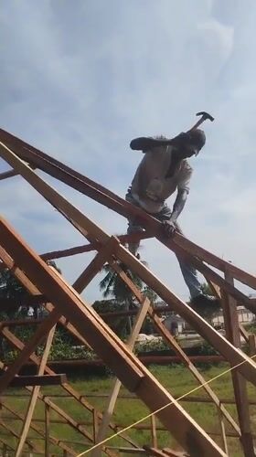 Construction worker on roof frame in Agbarha Otor, Nigeria
