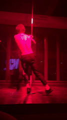 Pole dancing performance captured in red-lit Saint Petersburg room