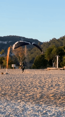 Paraglider prepares equipment during sunset at Fethiye beach