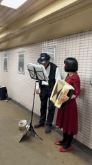 Street musicians and local commerce captured in Osaka