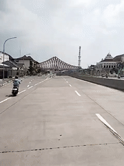 Red steel bridge documented in Surakarta during morning hours