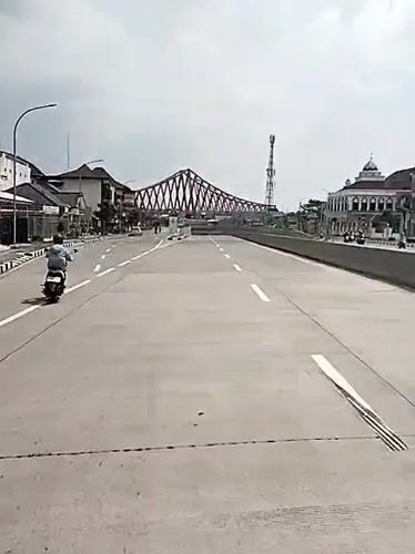 Red steel bridge documented in Surakarta during morning hours