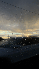 Rain-covered window overlooks water at dusk in Brest