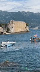 Tourists enjoy sunny afternoon at Budva's historic coastal attractions
