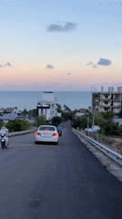 Moped passenger films scenic coastal ride in Vietnam