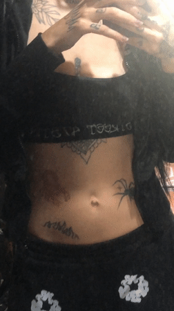 Tattooed person uses phone in bed in Buenos Aires