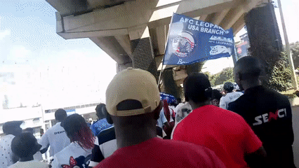 Crowd with flags gathers under Nairobi overpass