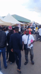 Large crowd gathers around vehicles in Abuja street scene