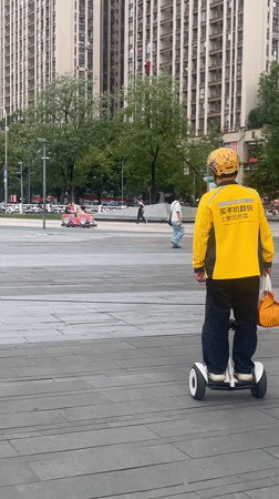 Yellow-clad rider on self-balancing scooter, Chongqing High-tech Zone