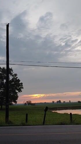 Sunrise over rural Kentucky pastures along a quiet country road