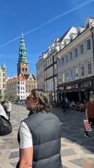 Pedestrians walk along geometric-tiled Copenhagen walkway