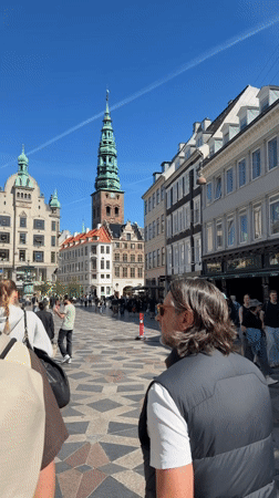 Pedestrians walk along geometric-tiled Copenhagen walkway