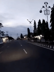 Motorcyclist travels empty road toward Lhokseumawe at dusk