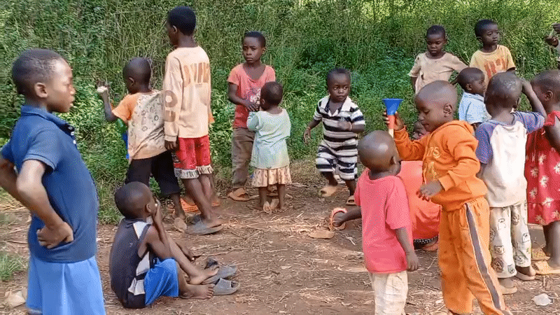 Children play games, toys in rural Congo village clearing