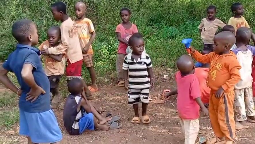 Children play games, toys in rural Congo village clearing