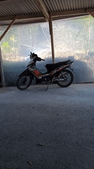 Motorcycle wash in progress at a rustic outdoor station