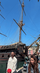 Sunny day at Genoa harbor features historic ship replica, aquarium fish