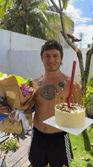 Man celebrates with birthday cake and flowers in North Kuta