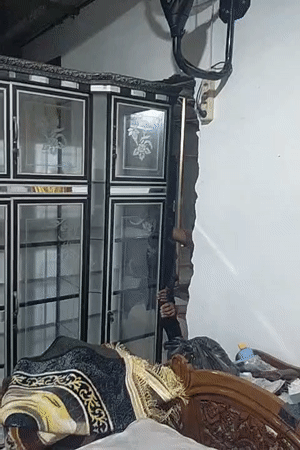 Men move decorative cabinet, reveal wall damage in Lhokseumawe