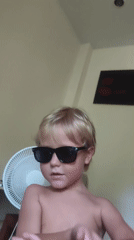 Child in sunglasses photographed in Thailand village