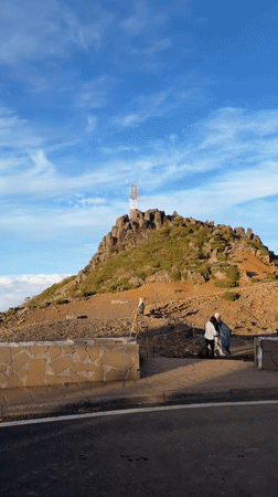 Tourists photograph scenic mountain views in Portugal's Santana region