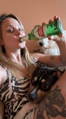 Woman enjoys beer with dogs in Tel Aviv apartment