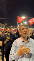 Red flags and solemn gestures at a Tehran night gathering