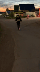 Children ride bikes, scooters in rural area during afternoon