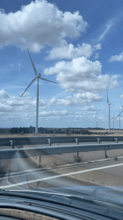 Wind turbines dot the Burgundy countryside from a highway drive.