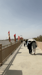 Red and yellow flags line pathway in Dunhuang