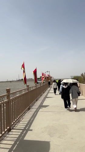 Red and yellow flags line pathway in Dunhuang