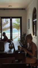 Woman in swimsuit works at table in Sri Lankan room