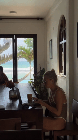 Woman in swimsuit works at table in Sri Lankan room