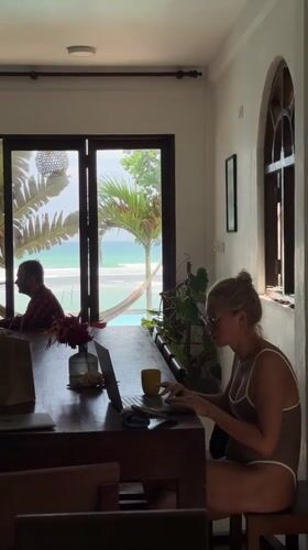 Woman in swimsuit works at table in Sri Lankan room