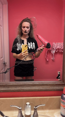 Person styling hair with dryer in Cape Coral bathroom