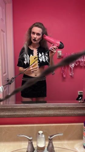 Person styling hair with dryer in Cape Coral bathroom