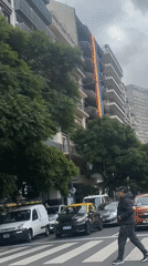 Rainbow banner displayed on Buenos Aires building amid street activity