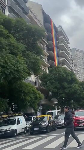 Rainbow banner displayed on Buenos Aires building amid street activity