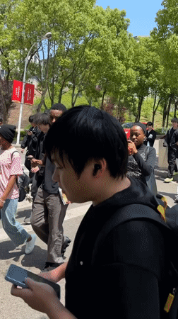 Students and pedestrians gather on sunny Jiangjin street