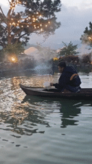 Ducks and a wooden boat at dusk on a Vietnamese lake