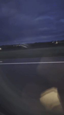 Vehicle passenger films nighttime airfield view in Luxembourg
