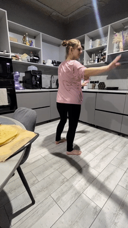 Woman dances barefoot in kitchen in Industrialny, Russia