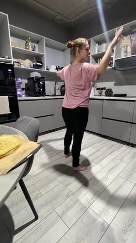Woman dances barefoot in kitchen in Industrialny, Russia
