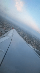 Aircraft departs Aksu during dramatic sunset, captured from passenger window