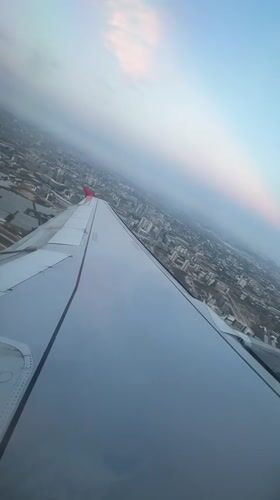 Aircraft departs Aksu during dramatic sunset, captured from passenger window