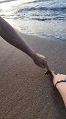 Solo beachgoer marks dawn with sand art, cigarette