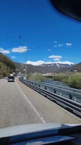Highway traffic flows through scenic Krasnaya Polyana mountains
