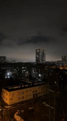 Woman in black robe observed in nighttime Kazan cityscape