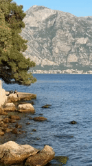 Tourist documents scenic Perast visit, fire trucks present