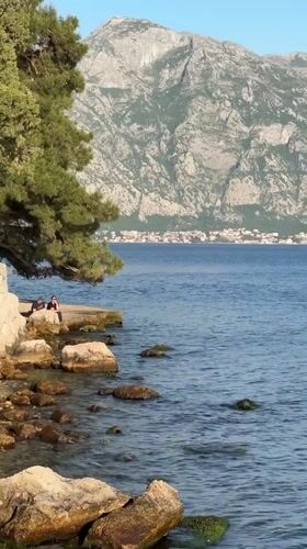 Tourist documents scenic Perast visit, fire trucks present